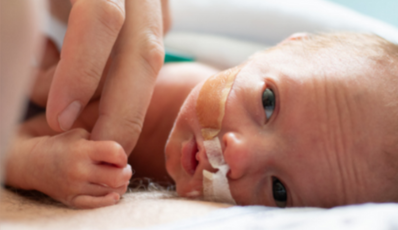 Parent touching their preterm neonate